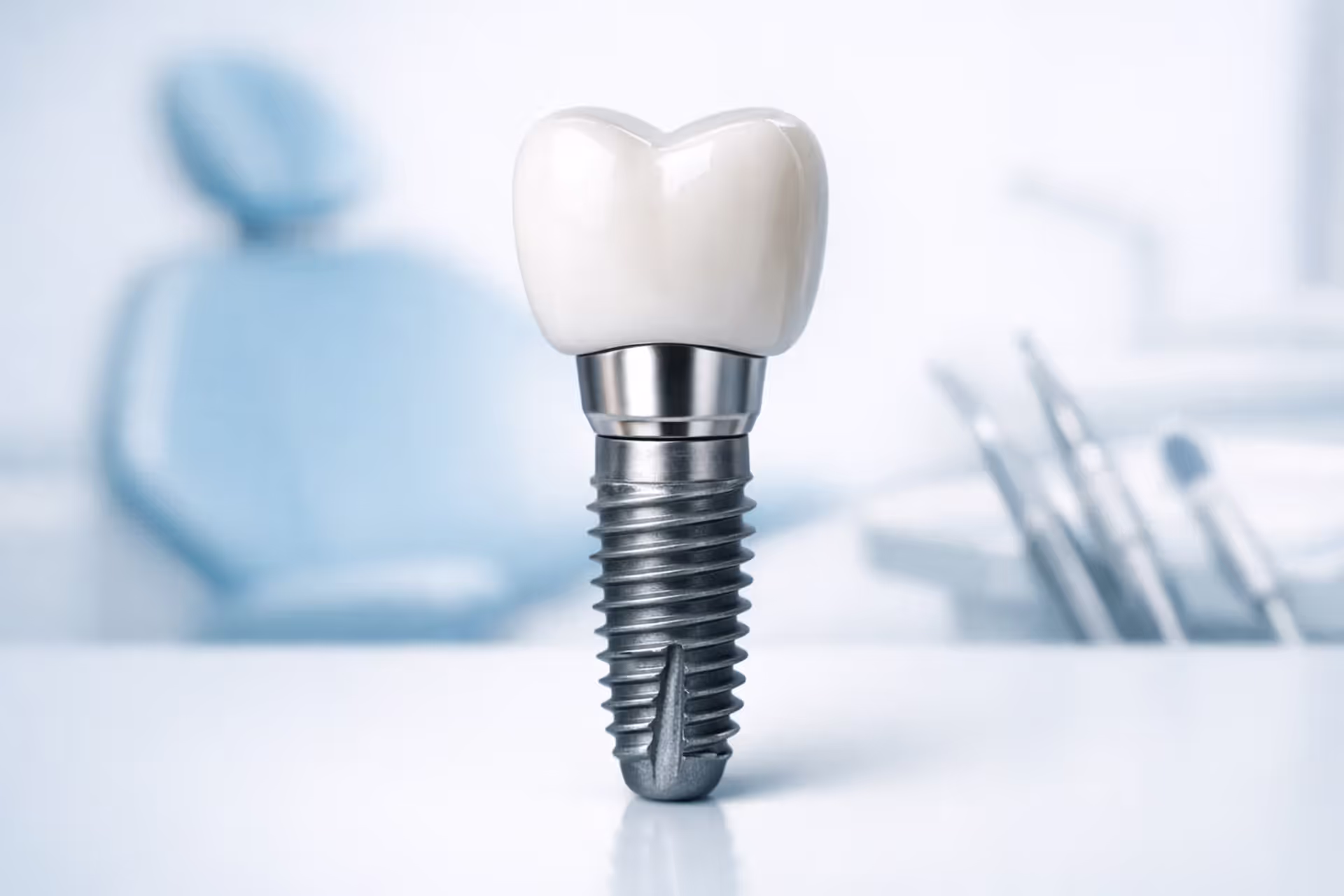 Close-up of a dental implant with titanium post, abutment, and ceramic crown on a clean medical background with blurred dental office