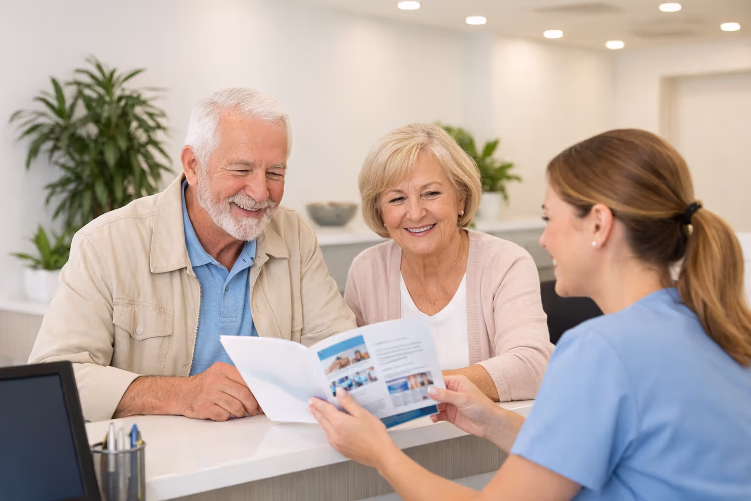 Senior couple talking to dental clinic receptionist about insurance coverage at front desk