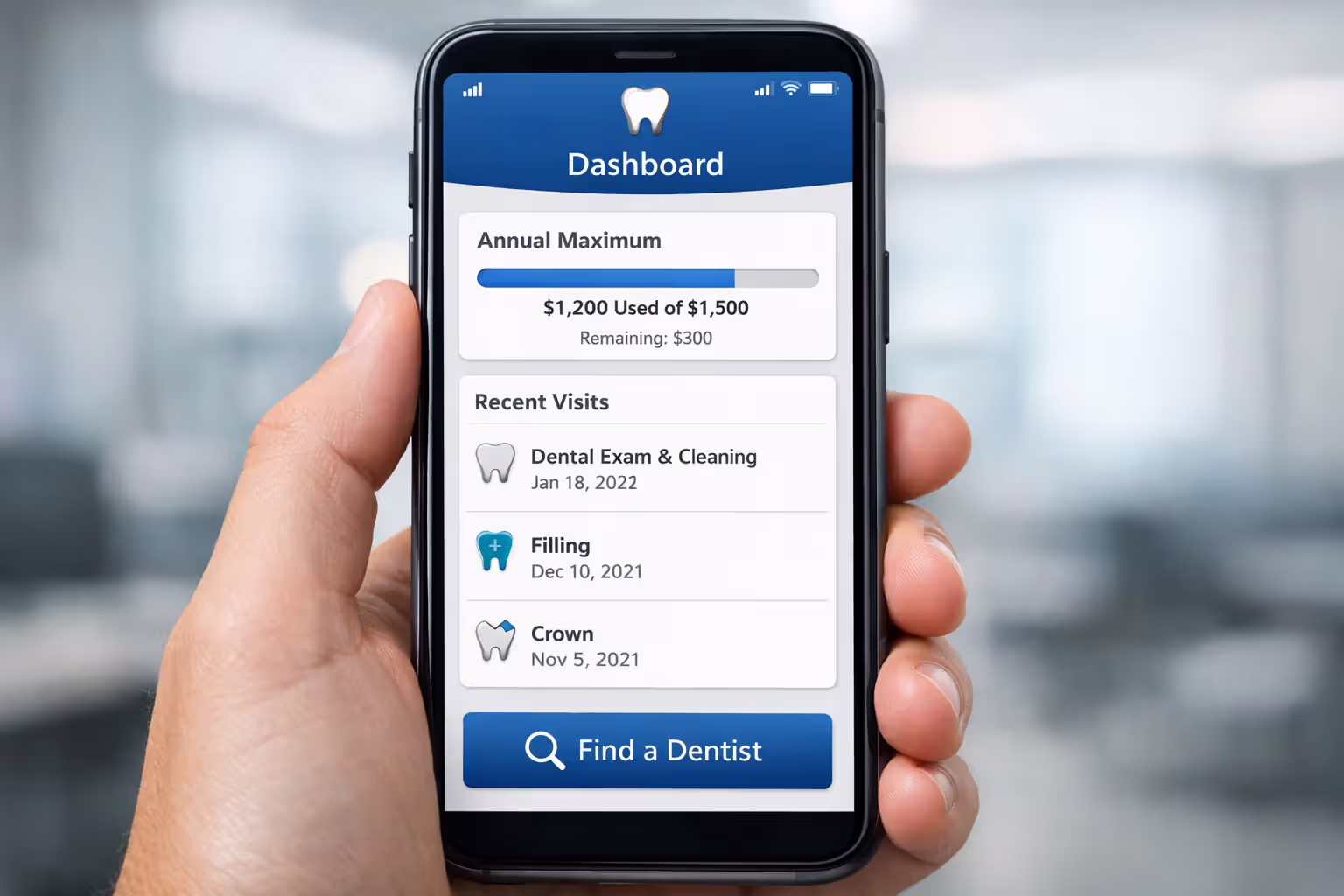 Close-up of a hand holding a smartphone displaying a dental insurance app dashboard with annual maximum tracker and claims history